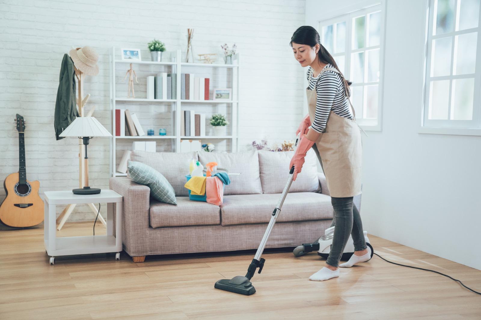 Wood Floor Staining in Carshalton – homeowner vacuuming an oak engineered wood floor as easy aftercare to protect the satin finish.