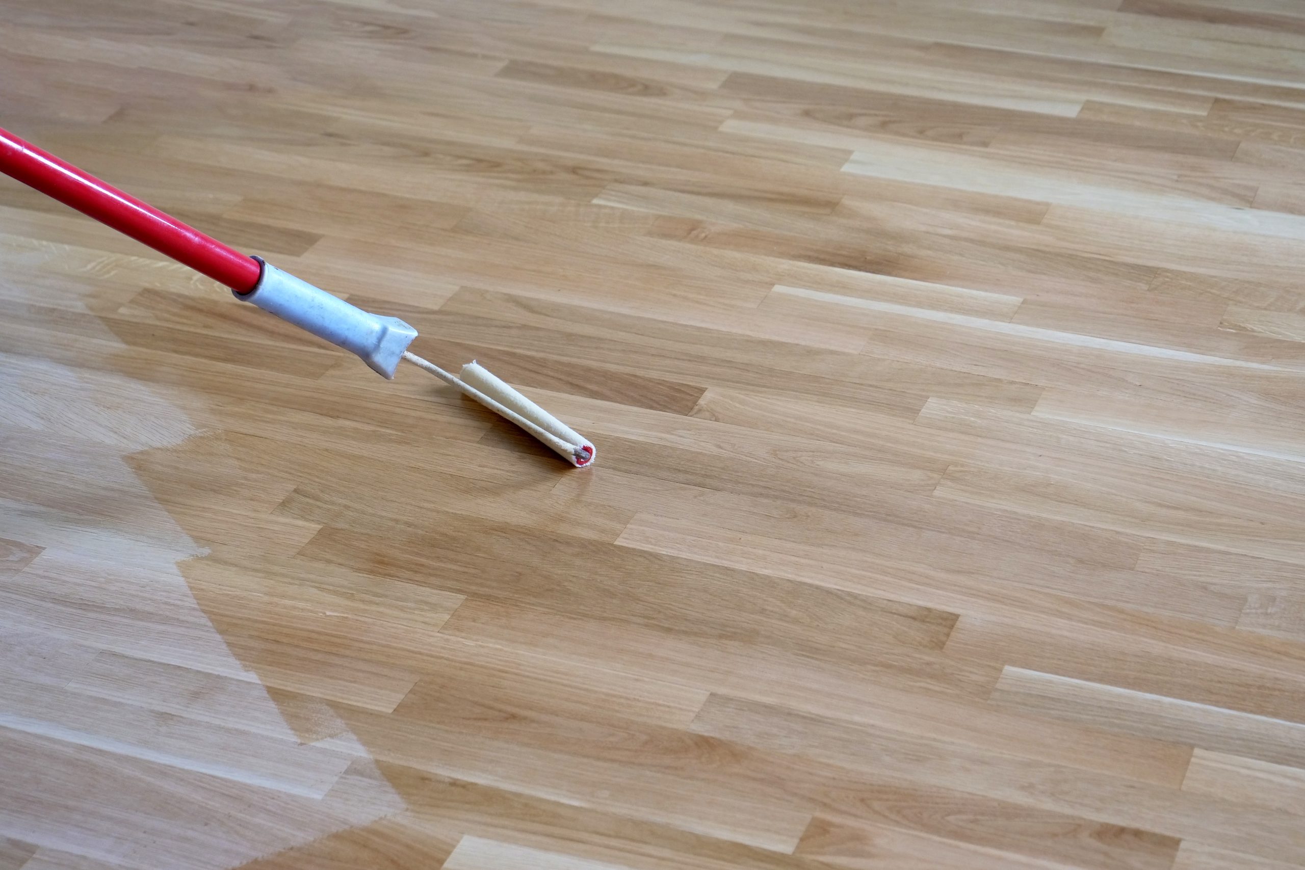 Wood Floor Staining in Carshalton – clear coat rolled over a freshly stained oak engineered wood floor for an even, satin finish.
