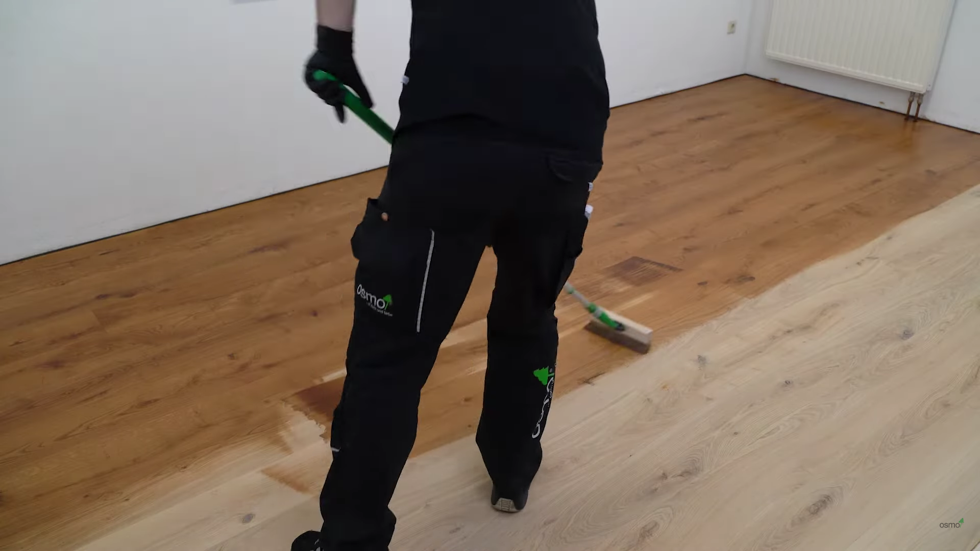 Professional Wood Floor Staining in Carshalton on an oak hardwood plank floor, mid-brown pigment being applied evenly with a pad applicator for a warm, uniform finish.