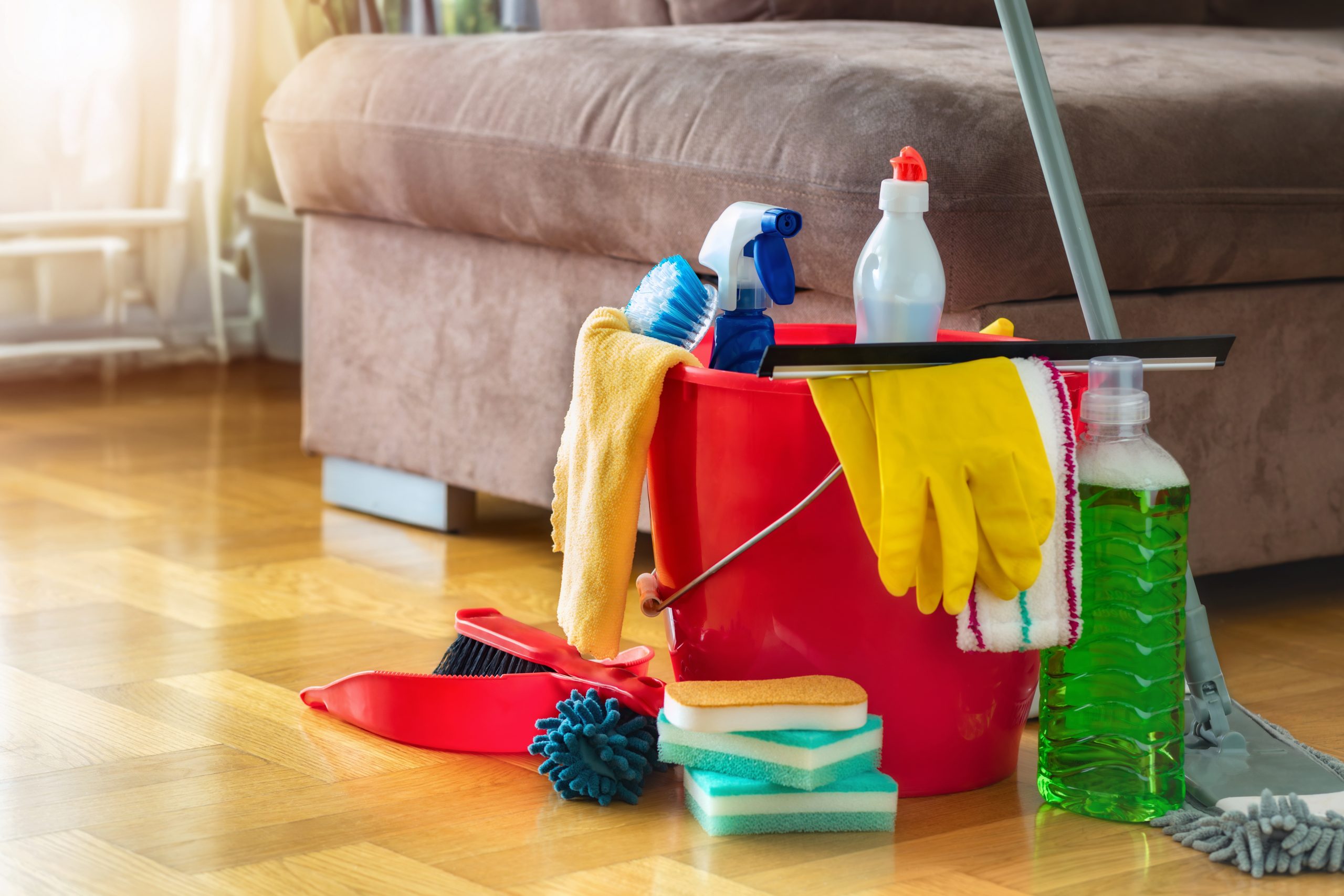 A collection of cleaning supplies on a polished oak herringbone parquet floor following a professional wood floor sanding service in Carshalton.