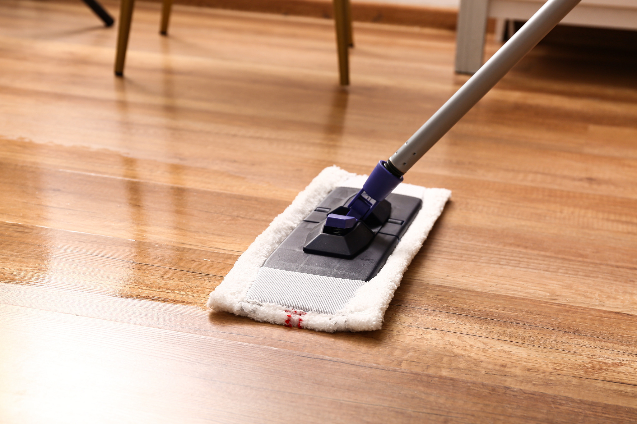 After Commercial Floor Sanding in Carshalton, a beech hardwood floor is being gently cleaned with a flat microfibre mop as part of routine aftercare.