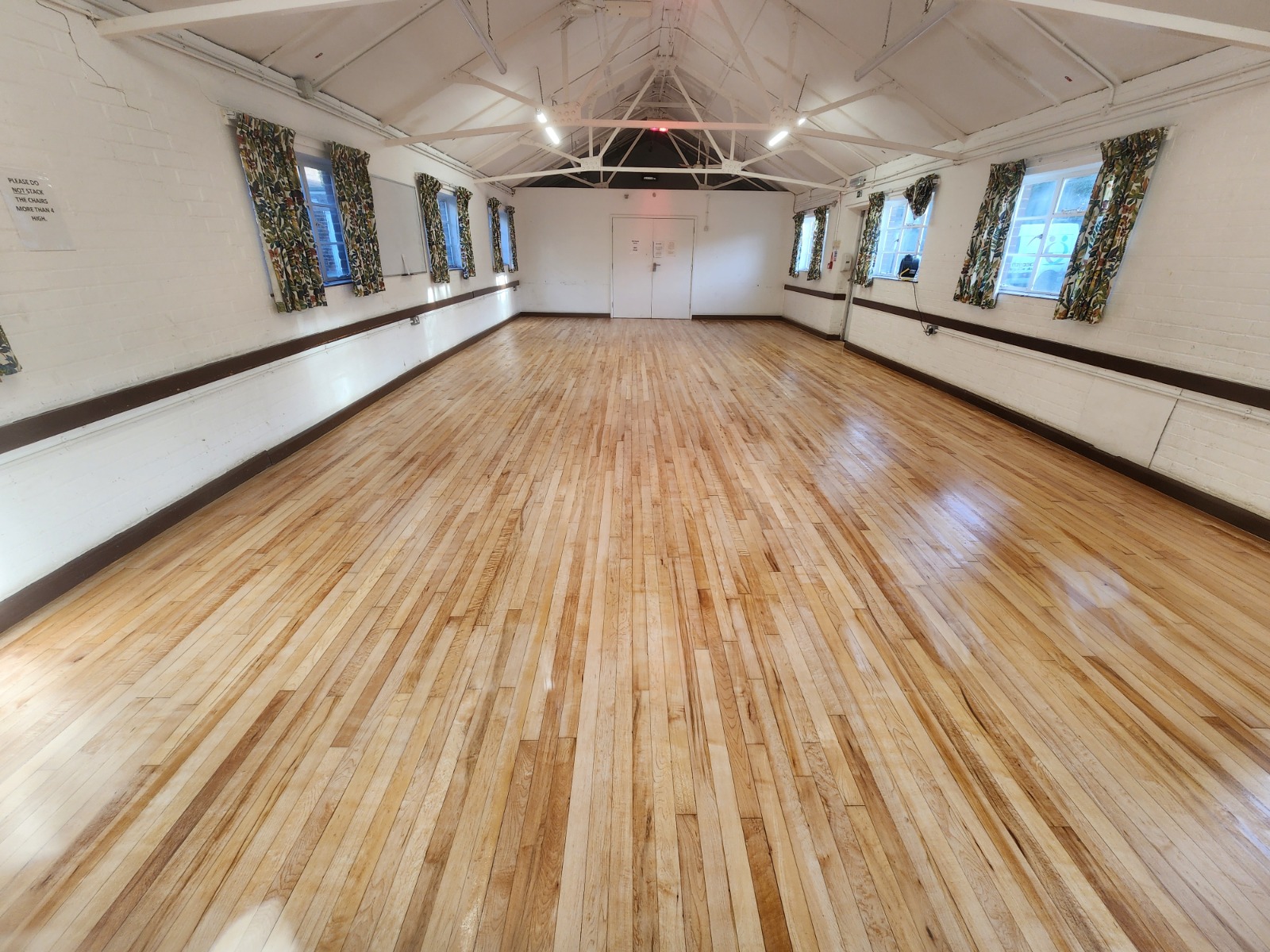 Freshly completed Commercial Floor Sanding in Carshalton on a maple strip hardwood hall floor, leaving a bright, smooth and glossy surface.