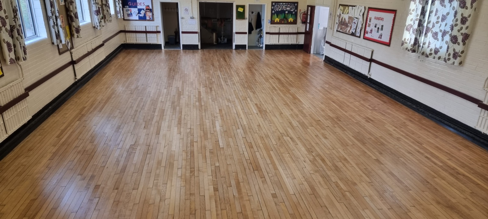 Commercial Floor Sanding in Carshalton on a maple strip hardwood hall floor, fully restored to a smooth, even finish for community use.